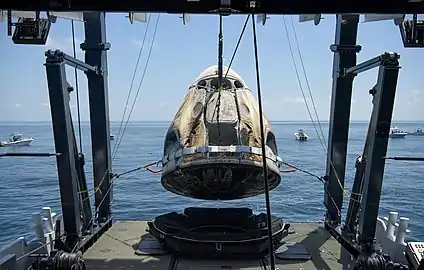 Crew Dragon Endeavour being hoisted onto aft of GO Navigator vessel.