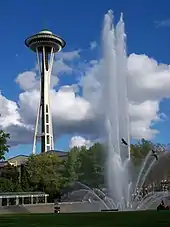 In this photograph, the "super shooters" installed by WET Design in 1995 are in operation and the water jets are reaching their peak height of approximately 120 feet (37 m). The ground level perspective creates an illusion the jet is nearly as tall as the Space Needle, shown in the background.