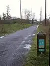 Most of the trail is bordered by fields and trees.