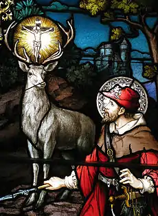 Stained glass window of St. Hubert, with the vision of the crucifix standing between the antlers of the stag or hart he was pursuing.