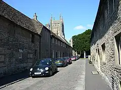 Street of gray stone houses. The church tower can be seen n the background