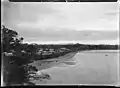 View of St Heliers Bay, Auckland, taken from Cliff Road looking west. St Heliers Bay Hotel and wharf are in the middle distance. Photographed by William Archer Price between 1910 and 1930.