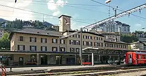 Wide four-story building with hip roof and clock tower