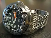 A watch with a stainless steel mesh bracelet.