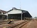 Bangil train station from west (Surabaya), showing its platforms, canopy, main building and some tracks.