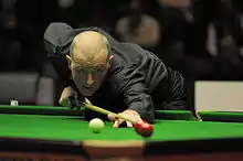 Davis, bent over the table, lining up a shot