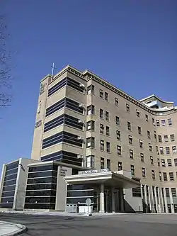 large multi-storey building of brick with large glass entry lobbies