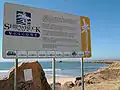 Sign at Stockton break wall, highlighting the shipwrecks that now form part of the breakwall.