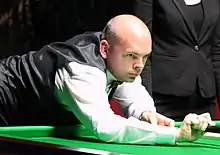 Stuart Bingham playing a shot with a rest