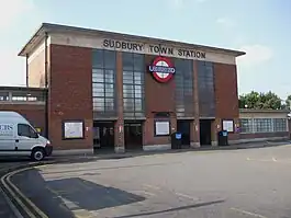 A red brick rectangular box shaped building with a concrete roof and two pairs of glazed screens