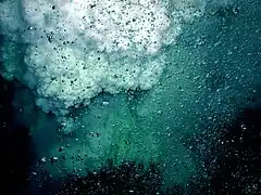 Bubbles of CO2 in the foreground; droplets of liquid sulfur rise in the background