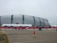 photo of State Farm Stadium taken from the parking lot, showing the domed stadium against an overcast sky