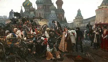 Mass of people in carts on left being taken to a barely visible background gallows in the right background while women and children look on worriedly. Wealthy aristocracy, including one on a horse, look on from the right. Multiple onion domes topping a large structure are visible in the left background.