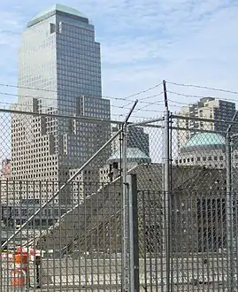 A few flights of concrete stairs seen from the side through a chainlink fence.