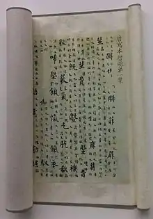 A scroll with Chinese writing, with large head characters