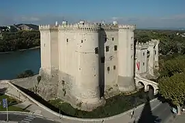 Strongly built medieval castle beside a river.