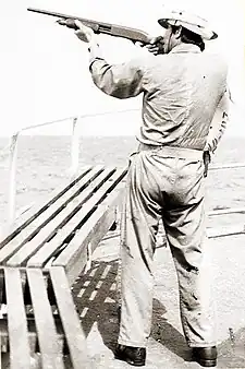 Image 28A merchant seaman aboard a fleet oil tanker practices target shooting with a Remington 870 12 gauge shotgun as part of training to repel pirates in the Strait of Malacca, 1984 (from Piracy)