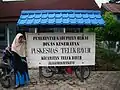A nameplate for a public health center protected with a cungkup at Teluk Bayur, Berau
