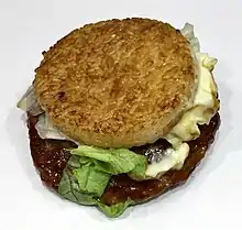 Ground beef patty between two disks made of compressed rice