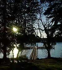 A dock extending out into a small lake near sunset