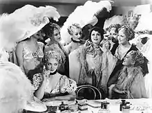 Anna Held (Luise Rainer) shows her jewels to the envious Audrey Dane (Virginia Bruce, seated)