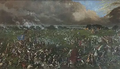 A battlefield on a green plain with water in the background. Soldiers, some on horseback, fight with swords and guns. Tents are visible in the distance.