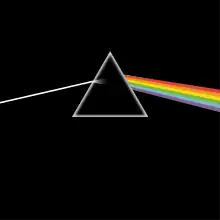 A prism refracting white light into a rainbow on a black background