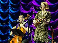 Two musicians performing on cello and ukulele