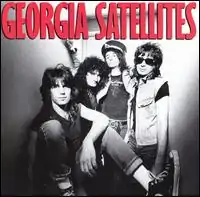 A black-and-white photo of the band. The album title appears above the band in red text.