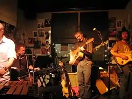 The High Llamas performing in 2008.From left: Murcott (obscured), Holdaway, Allum, O'Hagan, Fell (obscured) and Aves.