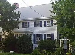 Front view of the Homestead, with trees on either side.