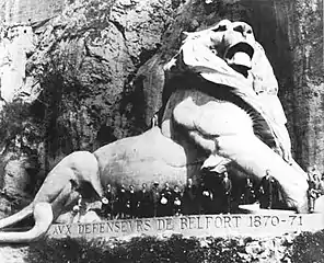 People standing in front of the sculpture, showing its enormous size.