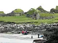 The sandy beach of Koltur and the old houses Heimi í Garði