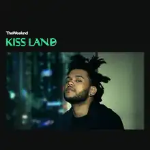 The cover features The Weeknd in his iconic dredlocks hairstyle looking directly at the viewer. A skyline is seen as a backdrop behind the windows. The words "KISS LANDS" appears in large green letters in a different font.