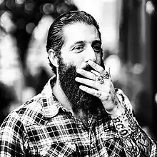 Image 60A man with sleeve tattoos, beard and flannel shirt, mid 2010s (from 2010s in fashion)