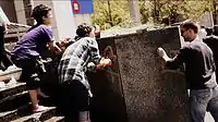 A group of volunteers clean spray paint off a wall