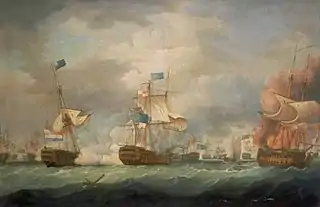 On a stormy sea beneath towering clouds, a number of sailing warships battle. In the foreground are three ships, two to the right of the ame bridged by clouds of smoke and the mainmast of the far right ship, which bears a prominent horizontally-striped flag is toppling. To the left of the frame a third ship drifts as flames leap from her deck.