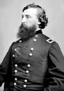 Black and white photo shows a heavily bearded man wearing a dark military uniform with the one star of a brigadier general on his shoulder tab.