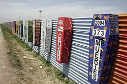 Border at Tijuana, Mexico and San Ysidro, California, United States with memorial coffins for those killed crossing this border. A straight-line border surveyed when the region was thinly populated.