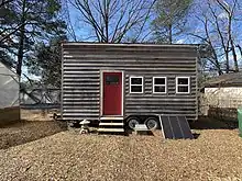 This tiny house on wheels provides a good example of more sustainable shelters.  Built from locally produced cypress wood, this tiny house on wheels gives students a sense of what a living system integrated into solar power, rainwater collection, and sustainable utilities looks like.