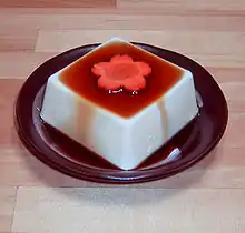 Japanese-style silken tofu with soy sauce and a decorative carrot slice