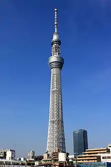 Ground-level view of a tall, slender, gray structure