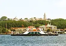 Modern photograph with the Bosporus in the foreground and the palace in the background atop a hill