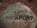 Babson Boulder near the MBTA tracks indicating the direction of Rockport