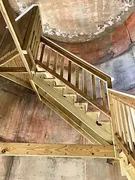 Inside view of the tower's renovations and the wooden staircase.