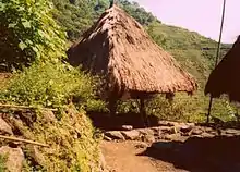 A traditional Ifugao house, called bale, with the Batad rice terraces in the background