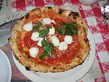 Image 55Traditional pizza Margherita, whose ingredients, tomato (red), mozzarella (white) and basil (green), are inspired by the colours of the national flag of Italy. (from Culture of Italy)