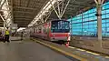 A commuter line train departing from the upper floor platform of Manggarai Station