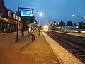 View of the tracks at night time, with a train arriving at the station.
