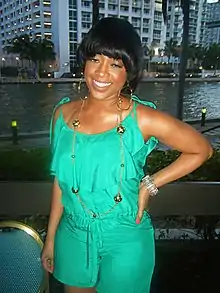 A photo of Trina in an aqua outfit.